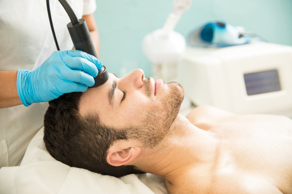 profile view good looking young man getting rf facial treatment health spa 2